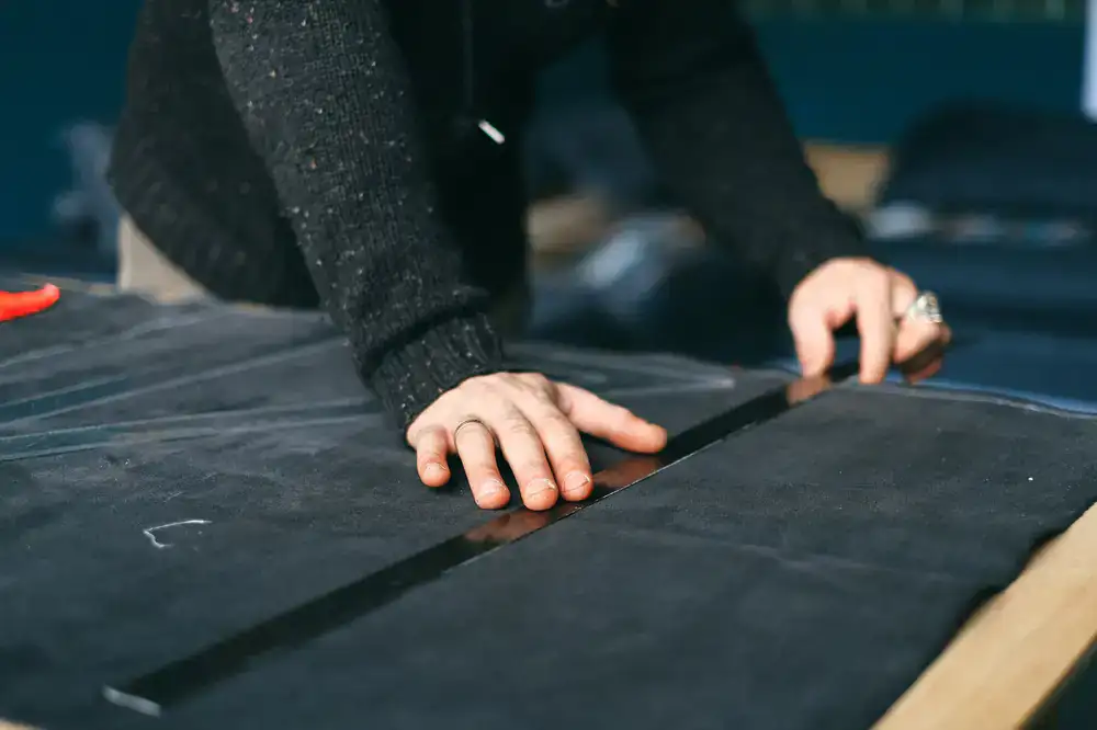 Artisan drafting a custom bespoke pattern on a workbench