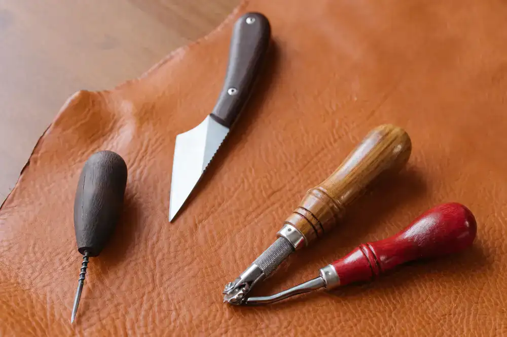 Close up of a diamond awl piercing thick leather