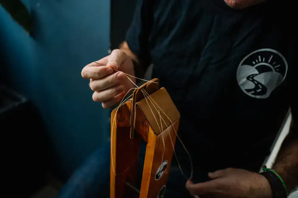 Hand stitching leather locked in a wooden pony